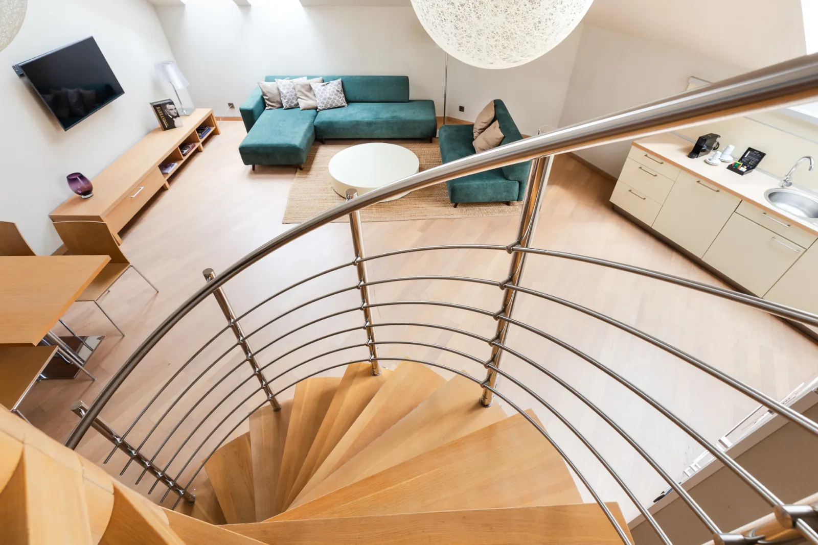 Maisonette spiral staircase rising to the upper-floor lounge and kitchenette